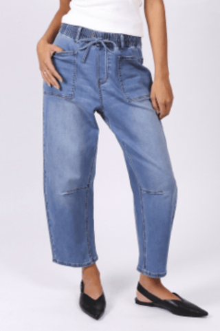 Woman wearing blue denim wide-leg pants with an elastic drawstring waistband.