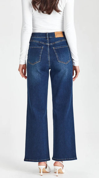 Back view of women's dark blue wide leg denim jeans with classic five-pocket styling.