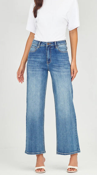 Woman wearing a white t-shirt and blue wide-leg denim jeans with white sandals