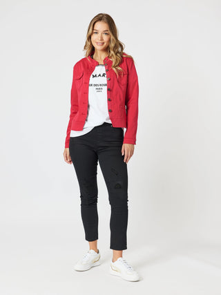 Woman wearing a red denim jacket, white graphic t-shirt, and black ripped skinny jeans.
