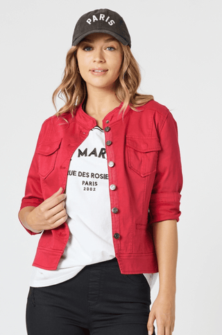 Woman wearing a red denim jacket over a white graphic t-shirt and a charcoal Paris cap.