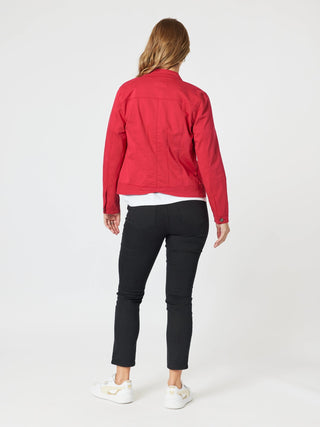 Rear view of a woman wearing a red denim jacket and black slim-fit pants