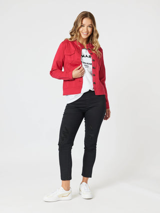 Woman wearing a red jacket, white graphic t-shirt, black skinny pants, and white sneakers.
