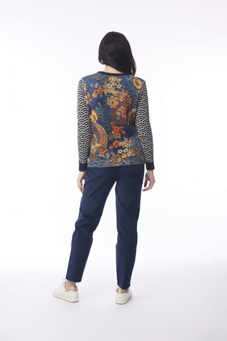 Woman wearing a blue floral print long sleeve top and navy blue pants.