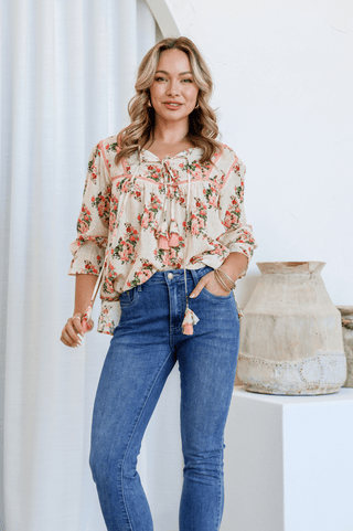 Woman wearing a floral print bohemian blouse and blue denim jeans.