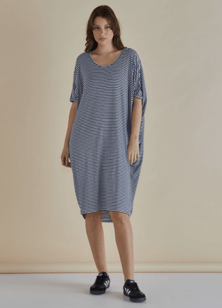 Woman wearing a blue and white striped short sleeve relaxed fit midi dress and black sneakers