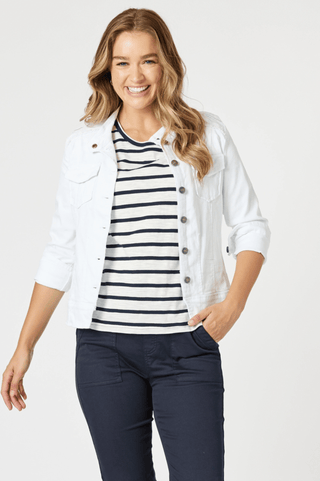 Smiling woman wearing a white denim jacket, striped t-shirt, and navy blue pants.