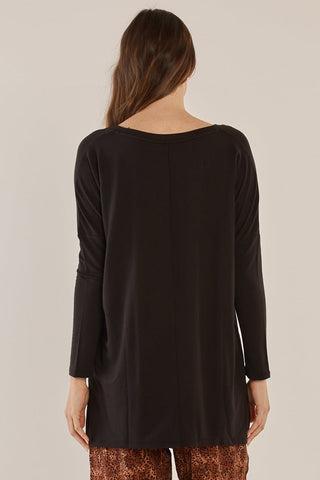 Back view of a woman wearing a black long-sleeve top and leopard print pants