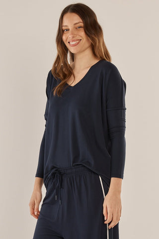 Woman wearing a navy blue v-neck long sleeve top and matching leisure pants.