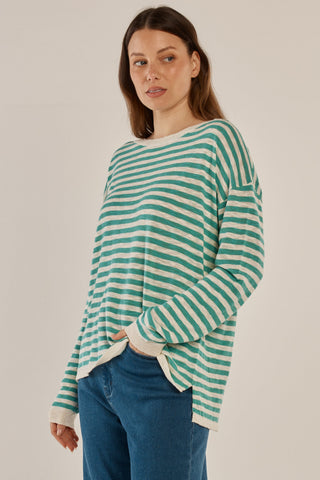 Woman wearing a teal and white striped long sleeve sweatshirt and blue jeans