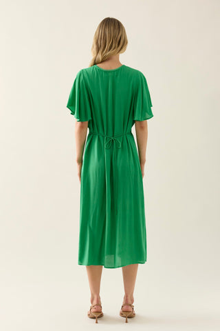 Back view of a woman wearing a green midi dress with flutter sleeves and waist tie.