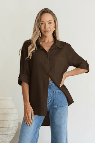 Woman wearing a brown button-down shirt and blue jeans