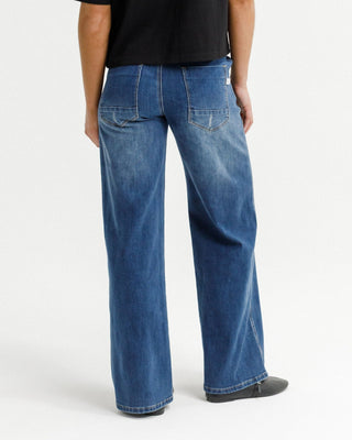 Woman wearing blue wide-leg denim jeans with back pockets.
