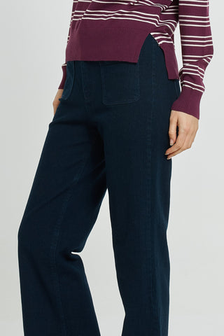 Woman wearing a purple and white striped sweater and dark navy wide-leg pants.
