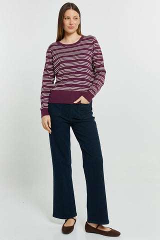 Woman wearing a burgundy and white striped sweatshirt with navy blue wide-leg pants.