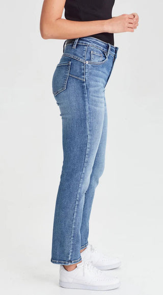 Woman wearing blue slim-fit denim jeans and white sneakers.