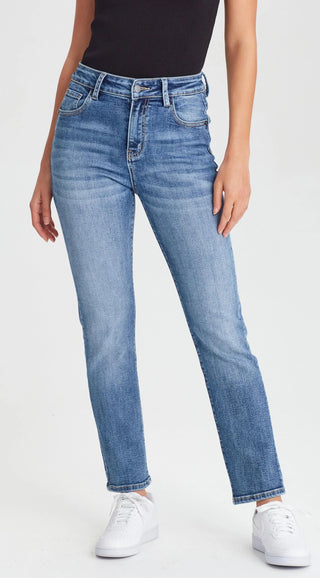 Woman wearing blue slim-fit denim jeans and white sneakers.