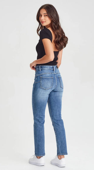 Woman wearing a black short sleeve top and blue straight leg denim jeans with white sneakers.