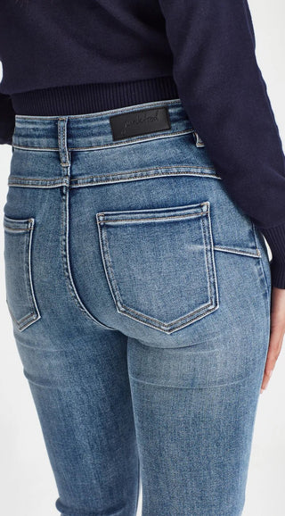 Rear view of a woman wearing blue high-waisted Junk Food denim jeans.
