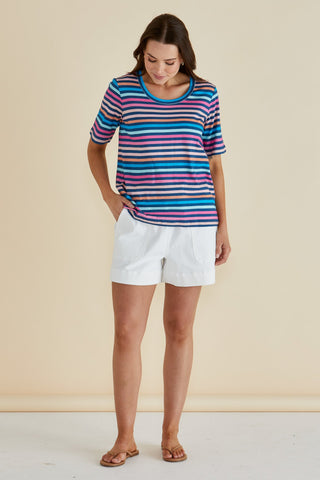 Woman wearing a colorful striped short sleeve t-shirt and white summer shorts.