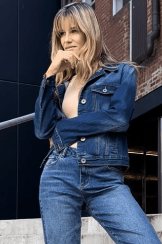 Woman wearing a classic blue denim jacket and matching jeans outfit.