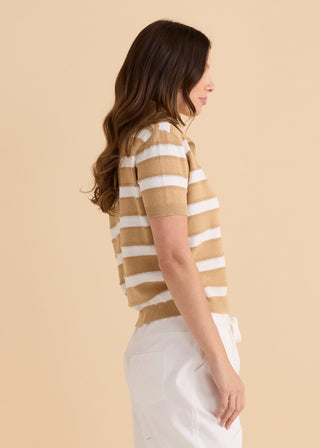 Woman wearing a tan and white striped short sleeve knit top and white pants