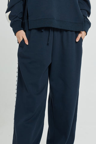 Navy blue women's leisure wear joggers with white side stripe detailing.