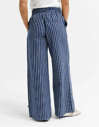 Rear view of woman wearing navy blue and white vertical striped wide leg pants