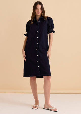 Woman wearing a navy blue denim button-up shirt dress with puff sleeves.