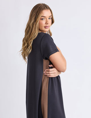 Woman wearing a charcoal grey short-sleeve dress with a brown side stripe detail.