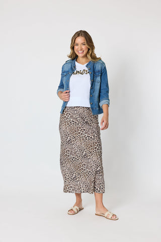 Woman wearing a denim jacket, white graphic t-shirt, and leopard print midi skirt.
