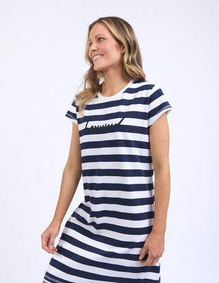 Woman wearing a navy and white striped short sleeve t-shirt dress.