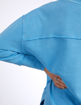 Close-up of a light blue long-sleeve sweatshirt with ribbed cuffs and relaxed fit.