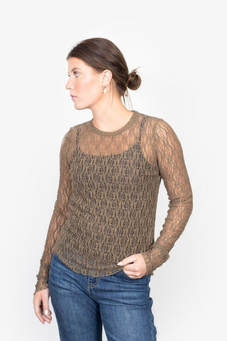 Woman wearing a brown lace long sleeve top and blue jeans