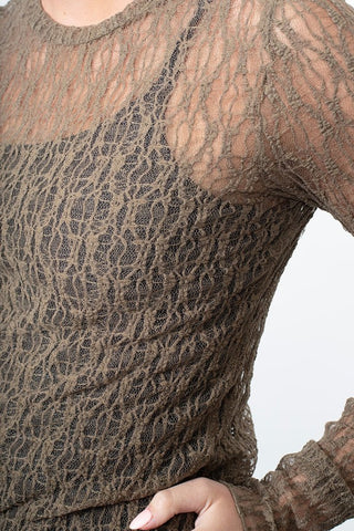 Close-up of a woman wearing a brown lace sheer long-sleeve top.