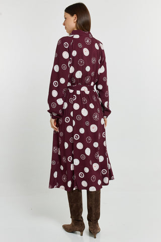 Back view of a woman wearing a burgundy printed midi shirt dress and brown suede boots.