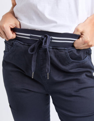 Close-up of navy blue drawstring leisure pants with a striped elastic waistband