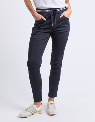 Person wearing navy blue slim-fit drawstring joggers and white sneakers