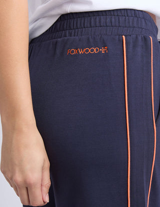 Navy blue Foxwood leisure wear pants with orange side stripe and embroidered logo.