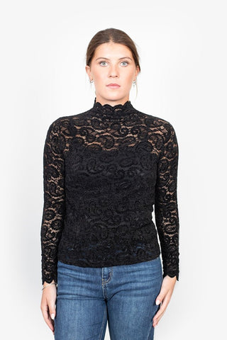Woman wearing a black lace high-neck long sleeve top and blue jeans.