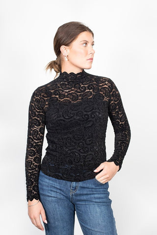 Woman wearing a black long sleeve lace high neck top and blue jeans