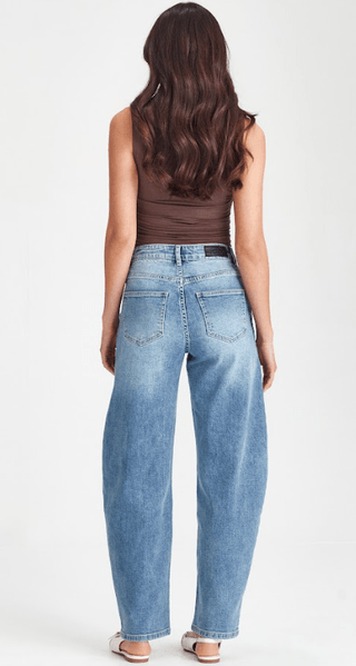 Woman from behind wearing a brown sleeveless top and light blue wide-leg denim jeans.