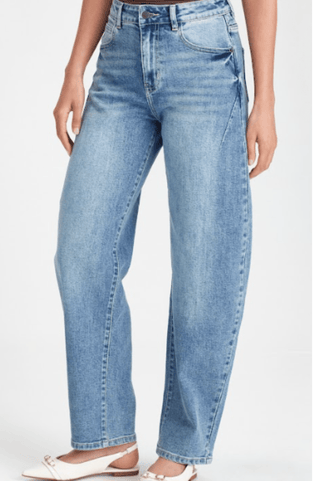 Woman wearing light wash high-waisted wide leg denim jeans and white flats.